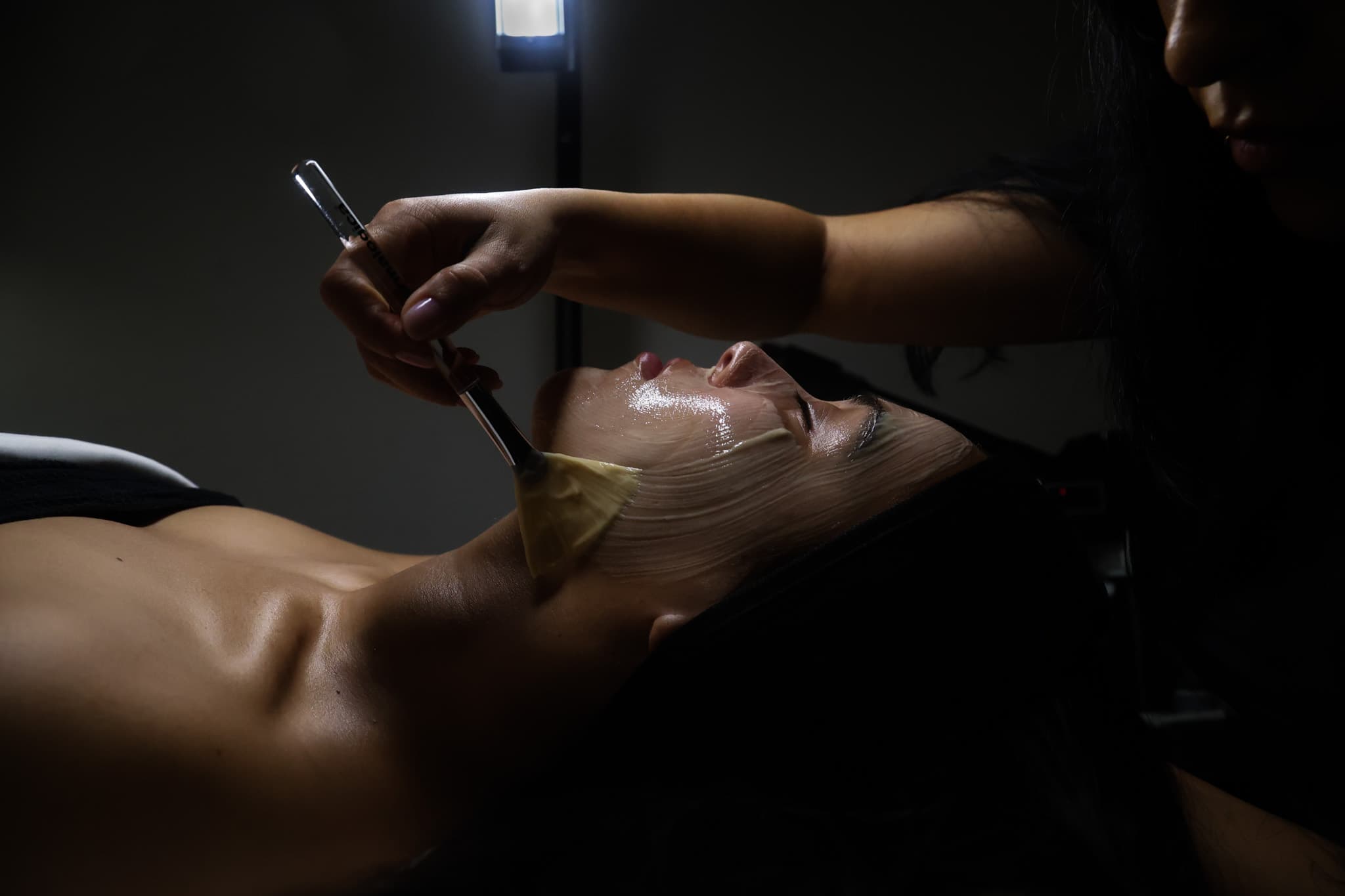 Facial mask being applied to a client’s skin during a facial treatment.