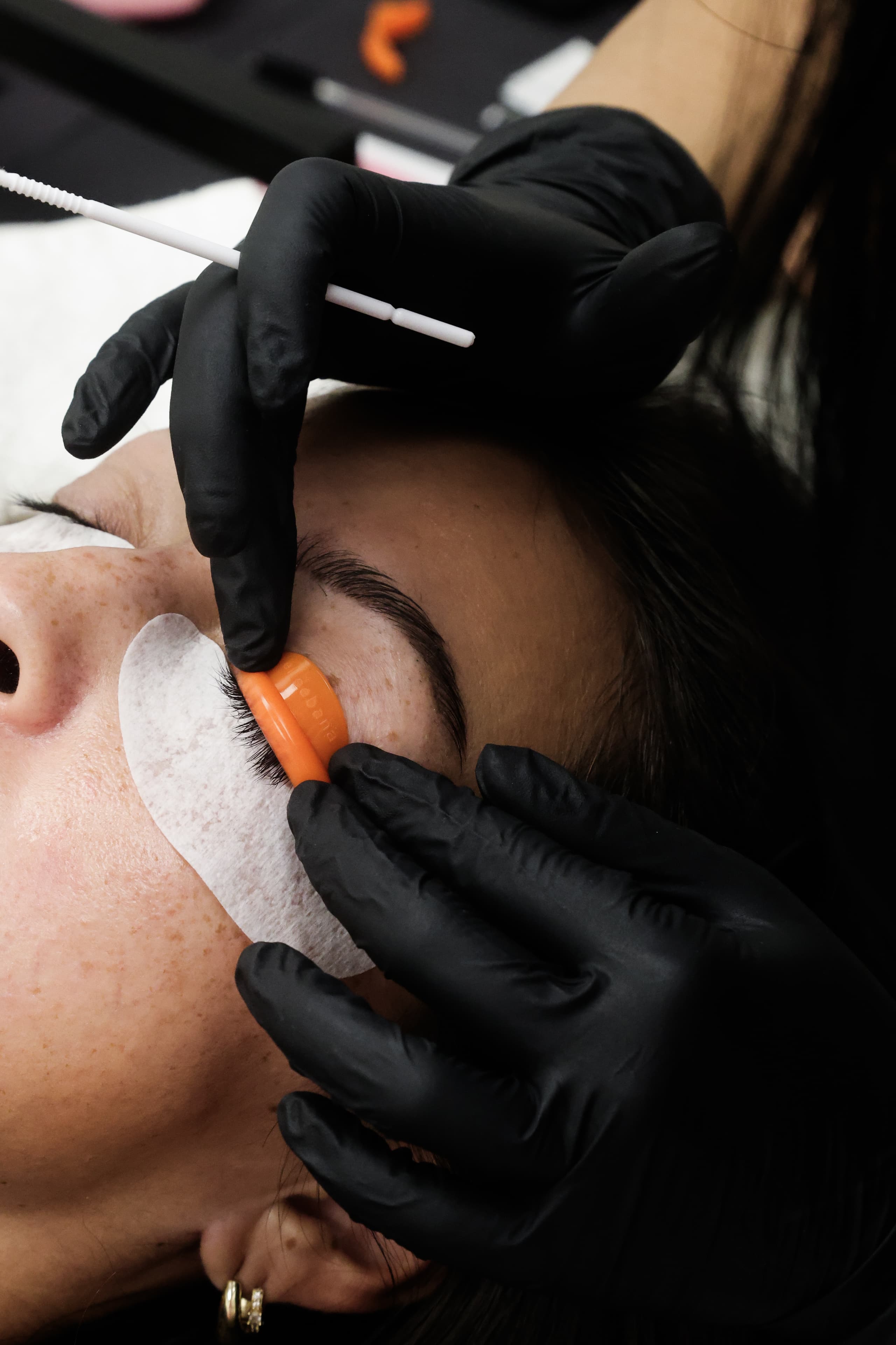 Close-up of a lash lift shield being applied to natural lashes.